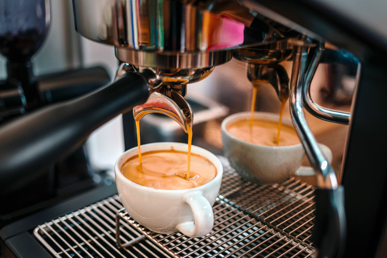 Frisch gebrühter Espresso läuft mit perfekter, haselnussbrauner Crema aus einer entkalkten Siebträgermaschine in eine weiße Tasse für unverfälschten Kaffeegeschmack.